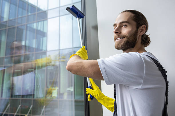 istock Young man cleaning the window with the window washer 2203816667