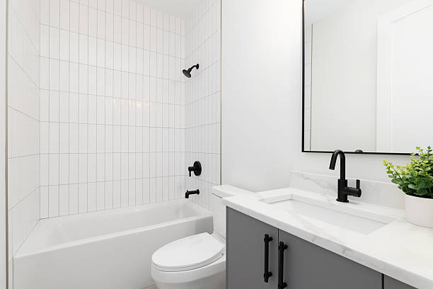 istock A bathroom with a grey cabinet, white countertop, and subway tile shower. 2203819508