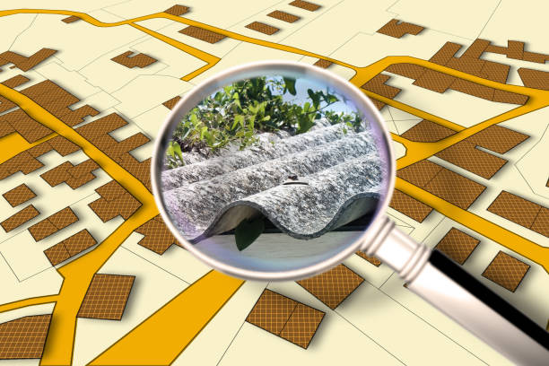 istock Mapping Asbestos-Cement Roofing, one of the most dangerous construction materials, in the buildings of our city - concept image with a magnifying glass against an imaginary city map 2203819829