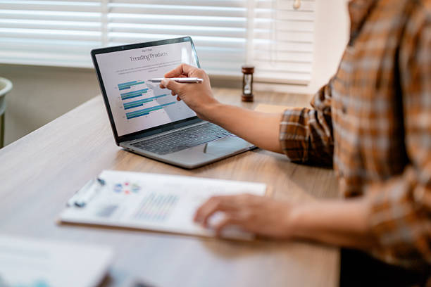 istock Professional businesswoman pointing at laptop screen, analyzing trending product data through graphs and charts for market strategy and business insights 2203821904