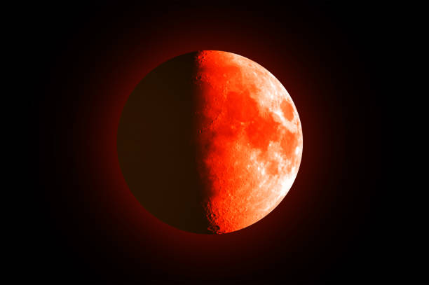 istock Eclipse - Blood moon with orange surface. Half of the moon is illuminated. 2203823320