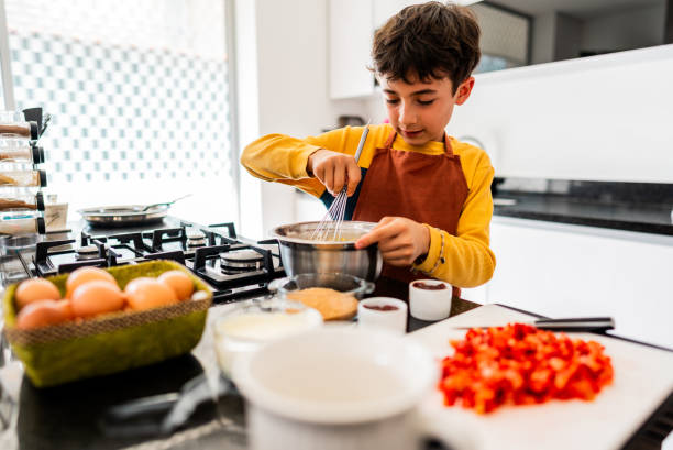 istock Child boy preparing cake at domestic kitchen 2203827455