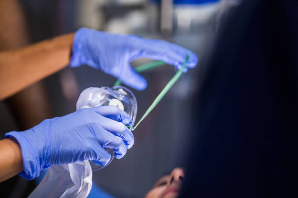 Close-up of gloved hands preparing an oxygen mask.  Medical care, healthcare.
