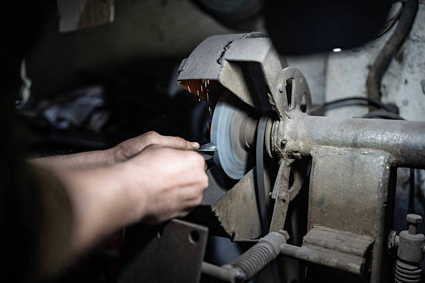 istock Worker Operating Grinding Machine in Industrial Workshop, Creating Metal Sparks 2203834103