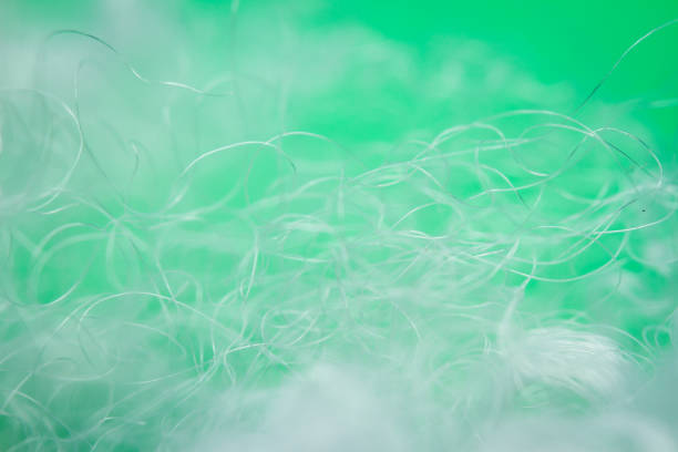 Close-up of a microfibre green coloured wash mitten on a synthetic rattan surface