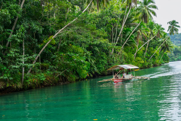 Loboc River, Bohol, Philippines - January, 2025: Loboc River in the Chocolate Hills in Bohol.  A couple on  Bangka boat on the river.