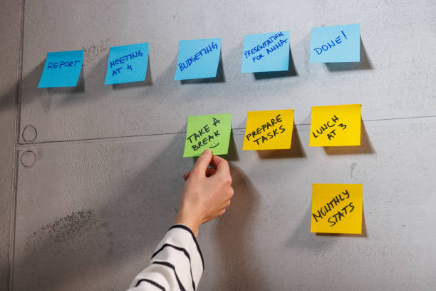 istock Hand Holding Note Among Colorful Office Sticky Notes on a Board 2203838013
