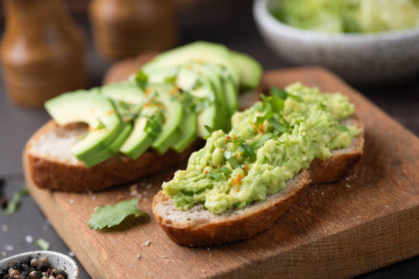 istock Toast with avocado and seeds on wooden board 2203840338