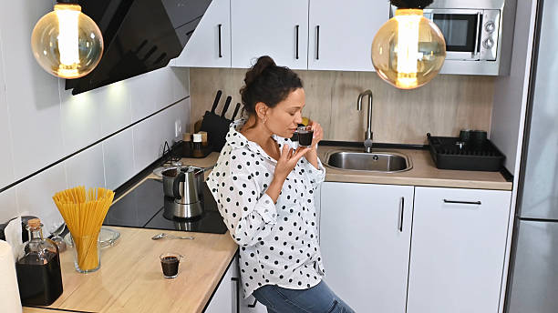 istock Woman Sipping Coffee in Modern Kitchen 2203842583