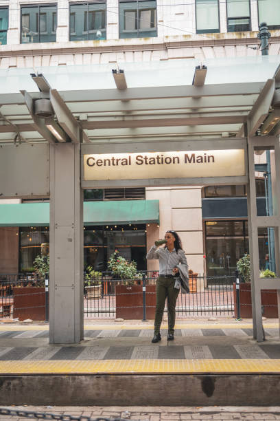 istock Woman standing at central station main in a cityscape setting 2203844618