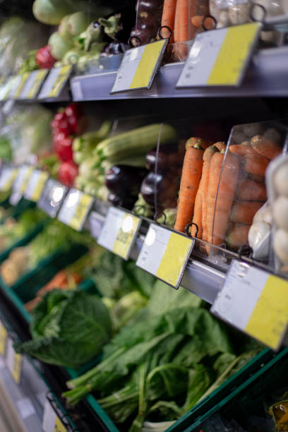 Vegetables in long open refrigerator at supermarket