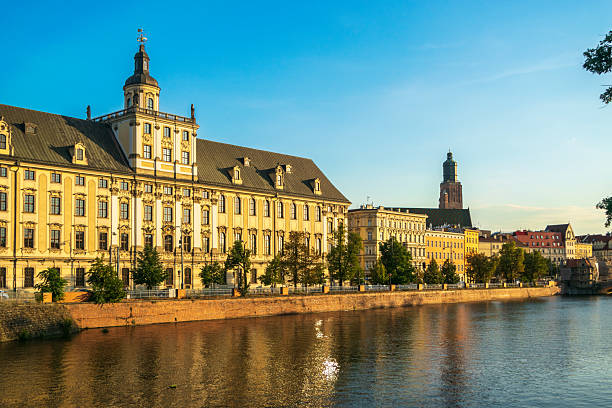 Wroclaw, Poland, August 10, 2022 The Oder River embankment in Wroclaw with majestic buildings at sunset. Baroque-style architecture and water reflections, editorial image
