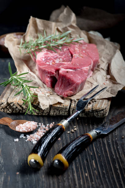 istock meat on a textured cutting board on wrapping paper. 2203850912