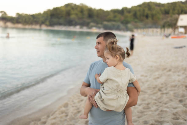 istock Father holding his one-year-old child on the seashore. 2203854434