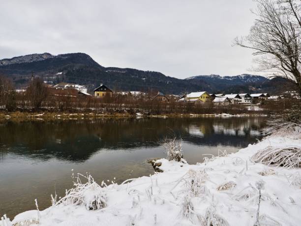istock Winter landscape with snowy riverbank and mountains. 2203855825