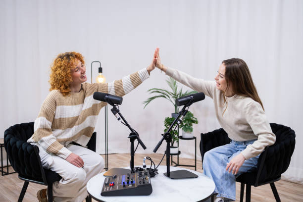 istock Two female podcasters giving high five celebrating podcast success 2203862944