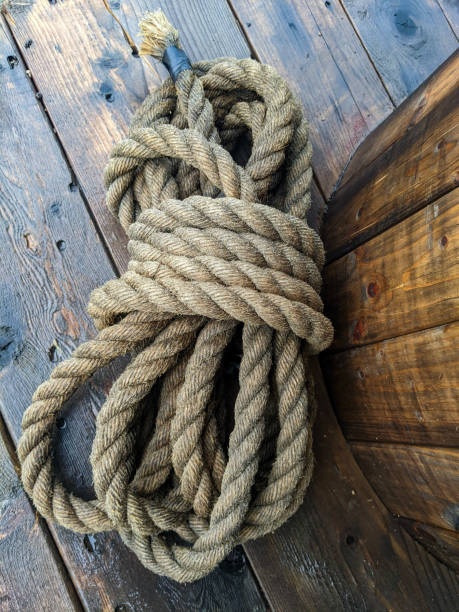 istock Coiled Hemp Rope on Rustic Wooden Deck During Overcast Weather 2203868901