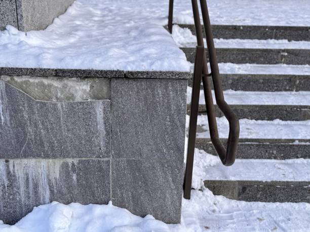 istock The winter scene features snow-covered steps and charming railings, while loose marble tiles spoil the entire design project. Bad frosty weather 2203868949