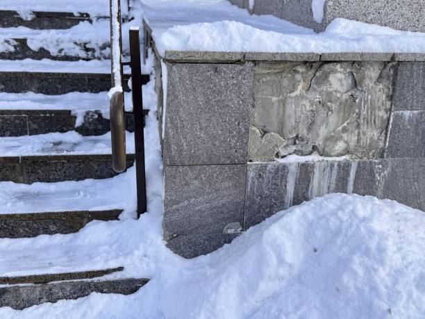 istock The winter scene features snow-covered steps and charming railings, while loose marble tiles spoil the entire design project. Bad frosty weather 2203869034