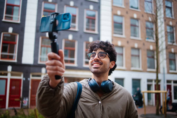 istock Young Smiling Man Takes Selfie Outdoors in Urban Environment 2203869424