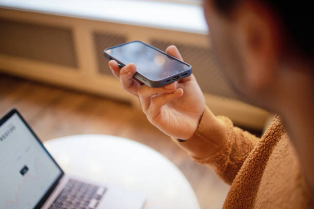 Person Using Smartphone with Voice Recording Feature Beside Laptop for Business