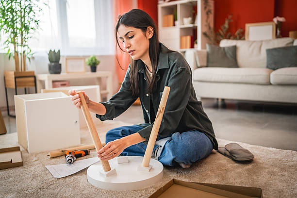 istock focus woman sit on floor and install small table at her new home 2203870480