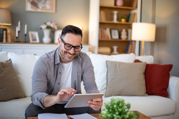 istock Happy man with digital tablet at home 2203875087