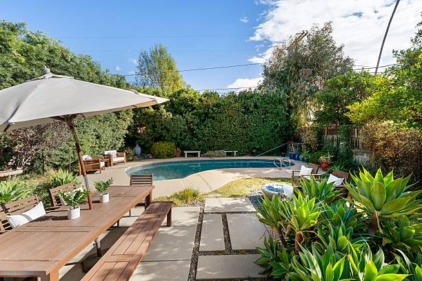 istock Resort-style backyard with a pool and lush landscaping. 2203875678