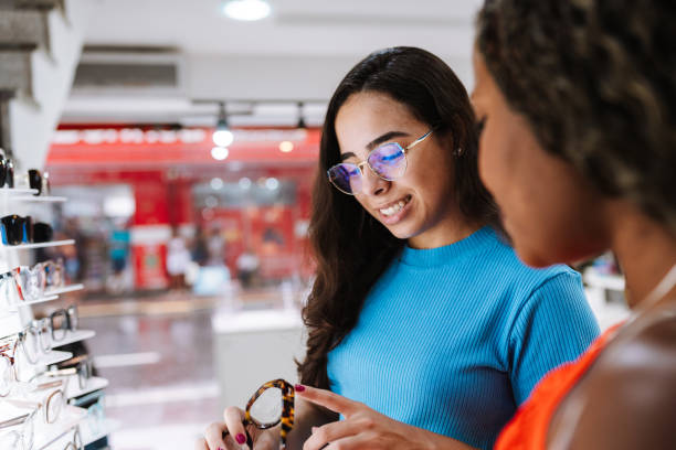 istock Optical shop assistant showing glasses to a customer 2203885616