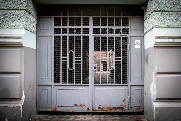 istock Gray Metal Gate with Rust and Warning Sign on Urban Building 2203886927
