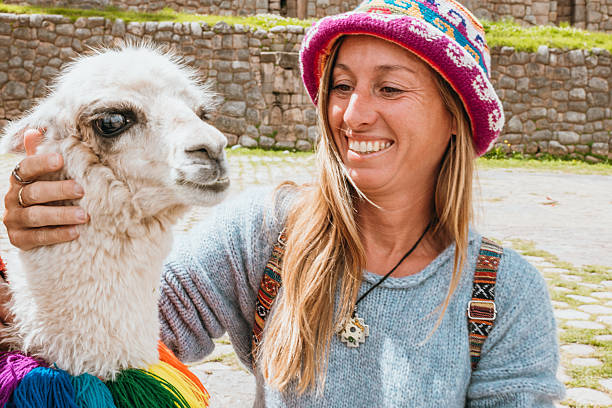 istock Woman Smiling While Petting a Llama in Outdoor Setting 2203888844