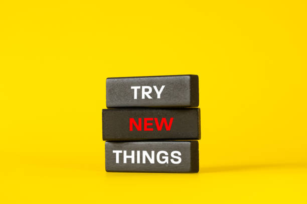 istock Try new Things phrase. Try new Things symbol on expressive black wooden blocks. Beautiful yellow background. business and conceptual words, Motivation and inspiration slogan. Copy space. 2203888988