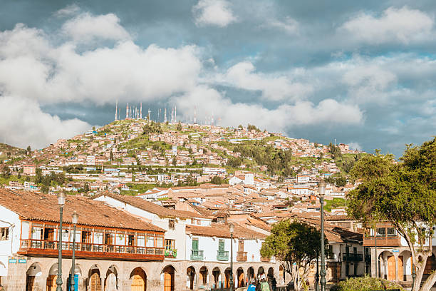 Quaint town square with colonial-style architecture. Scenic view of buildings against a hilltop. Picturesque urban landscape with a dramatic sky.