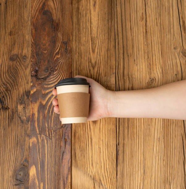 istock Hand Holds Cup, Empty Paper Cup in Hands, Coffee Mug, Teacup, Hot Beverage Mockup, Cup in Arms 2203890994