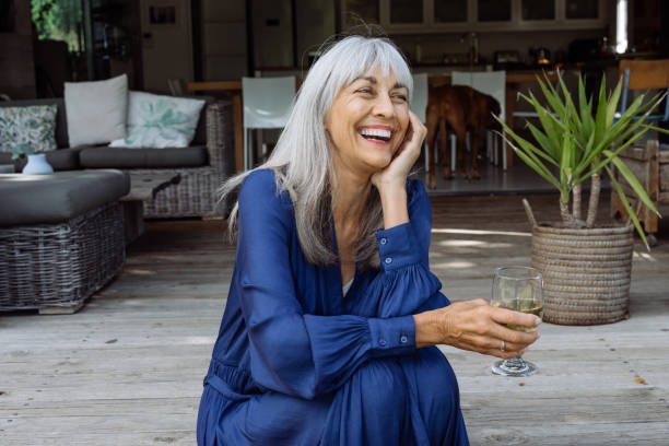 istock With elegance and charm, she relaxes outdoors, savoring a quiet moment with a refreshing drink in hand. 2203891440
