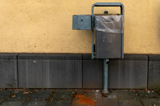 istock Metal waste container attached to a wall in an urban setting during daylight hours 2203892622