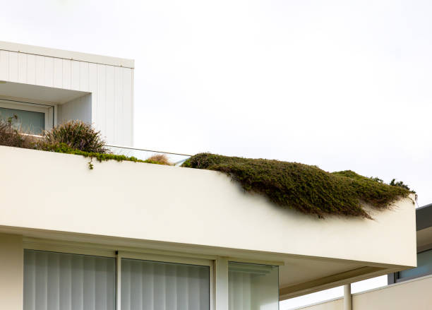 Bueautiful roof balcony with two tables and flowerbed on a tiled roof.