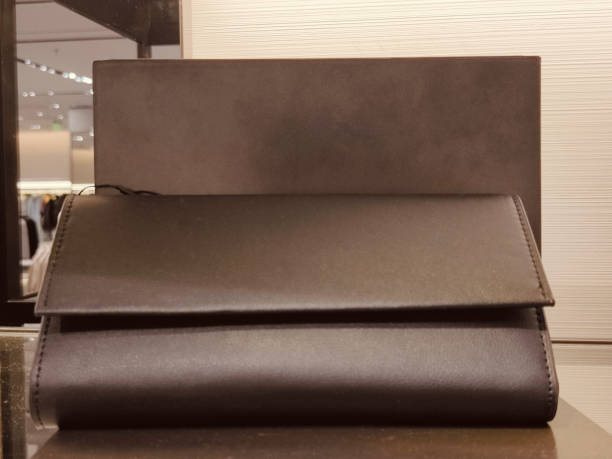 istock The black leather wallet is on display at the store, with two folded compartments in dark brown and grey colors 2203895132