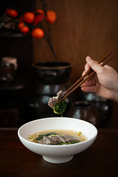 istock Pork noodle soup in bowl with chopsticks on wooden table 2203896254