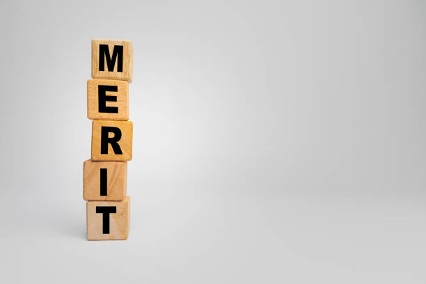 istock merit word text on stack wooden blocks isolated on white background. copy space 2203902181