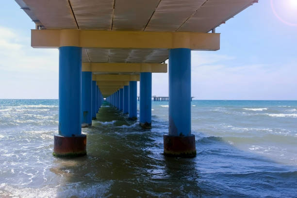 istock View on seascape with stormy wave and cloudy sky from under the pier. 2203905253