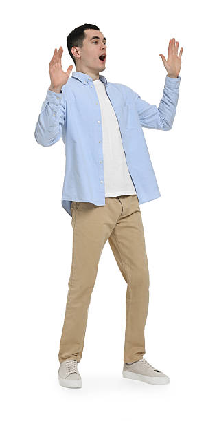 istock Shocked man in light blue shirt and beige pants on white background 2203910465