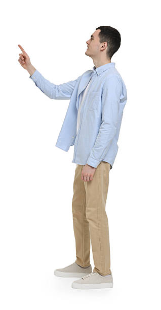 istock Young man pointing at something on white background 2203910473