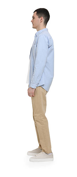 istock Young man in light blue shirt and beige pants on white background 2203910555