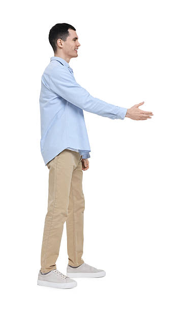 istock Young man in light blue shirt and beige pants on white background 2203910679