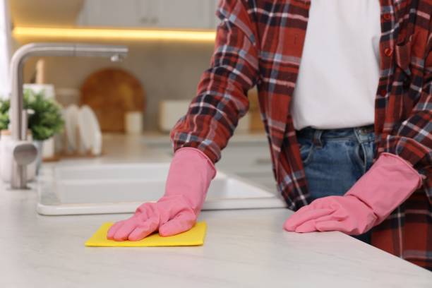 istock Woman cleaning white marble table with microfiber cloth in kitchen, closeup 2203911900