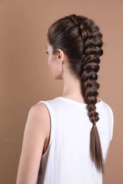 istock Woman with braided hair on light brown background, back view 2203912013