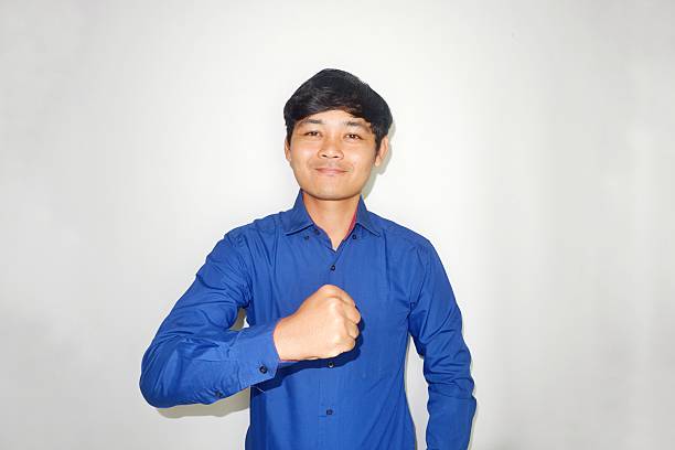 an Indonesian man is taking a selfie with a random expression and style then blue shirt, self potrait