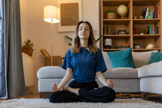 istock Serene young woman practicing mindfulness meditation in her living room, finding inner peace and balance 2203912795