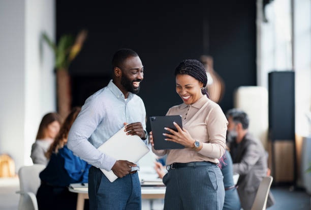 istock Coworking Colleagues Discussing on Digital Tablet in Corporate Environment 2203913890